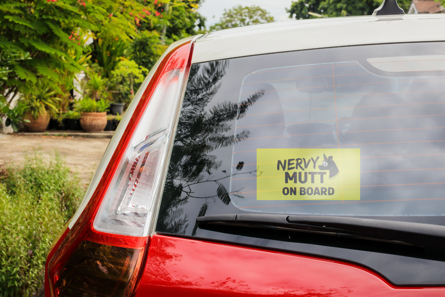 Nervy-Mutt-nervous-dog-on-board-car-sticker-decal-in-rear-window-of-red-car