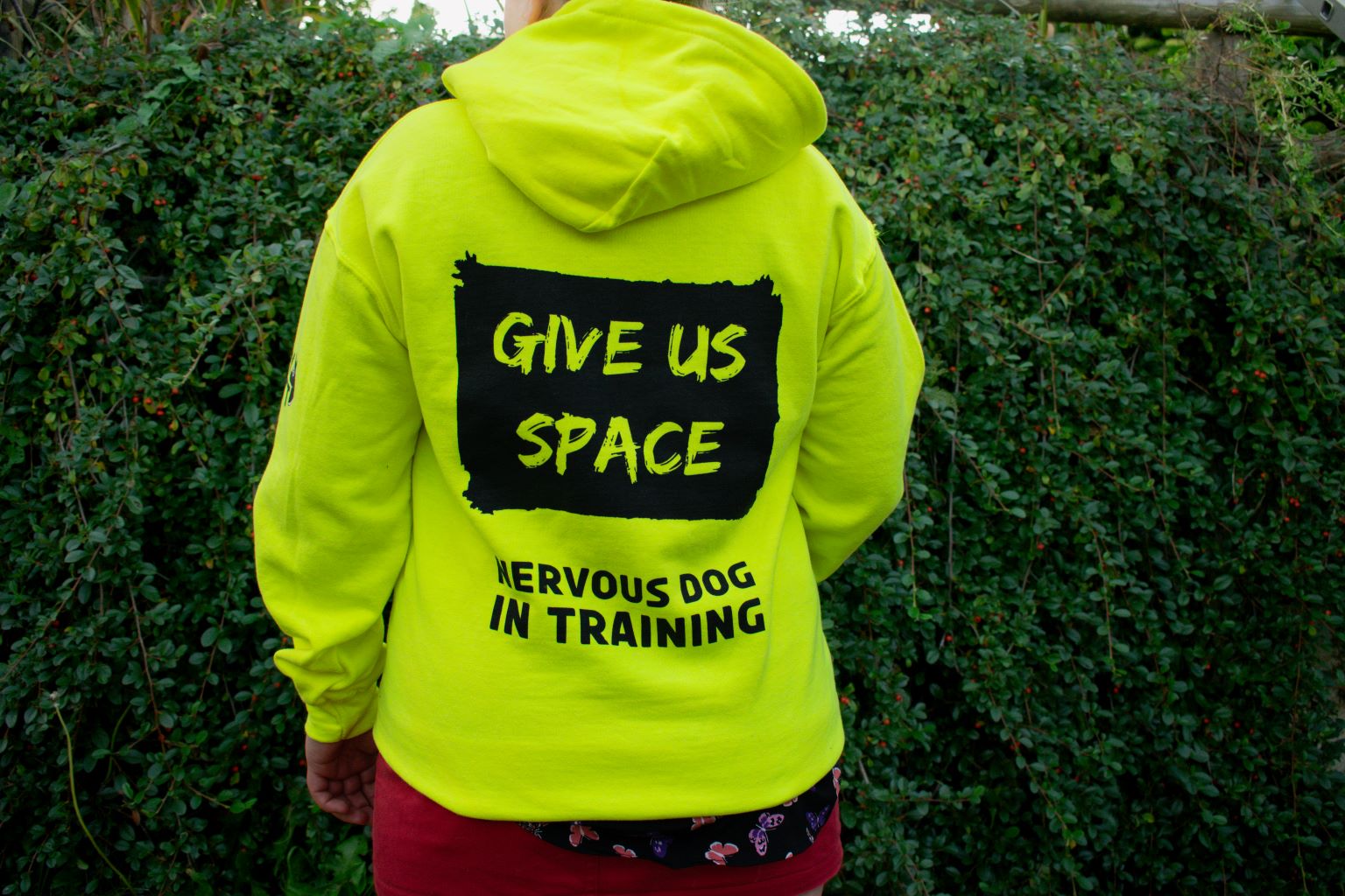 lady-showing-back-of-printed-nervy-mutt-high-vis-nervous-dog-in-training-hoody